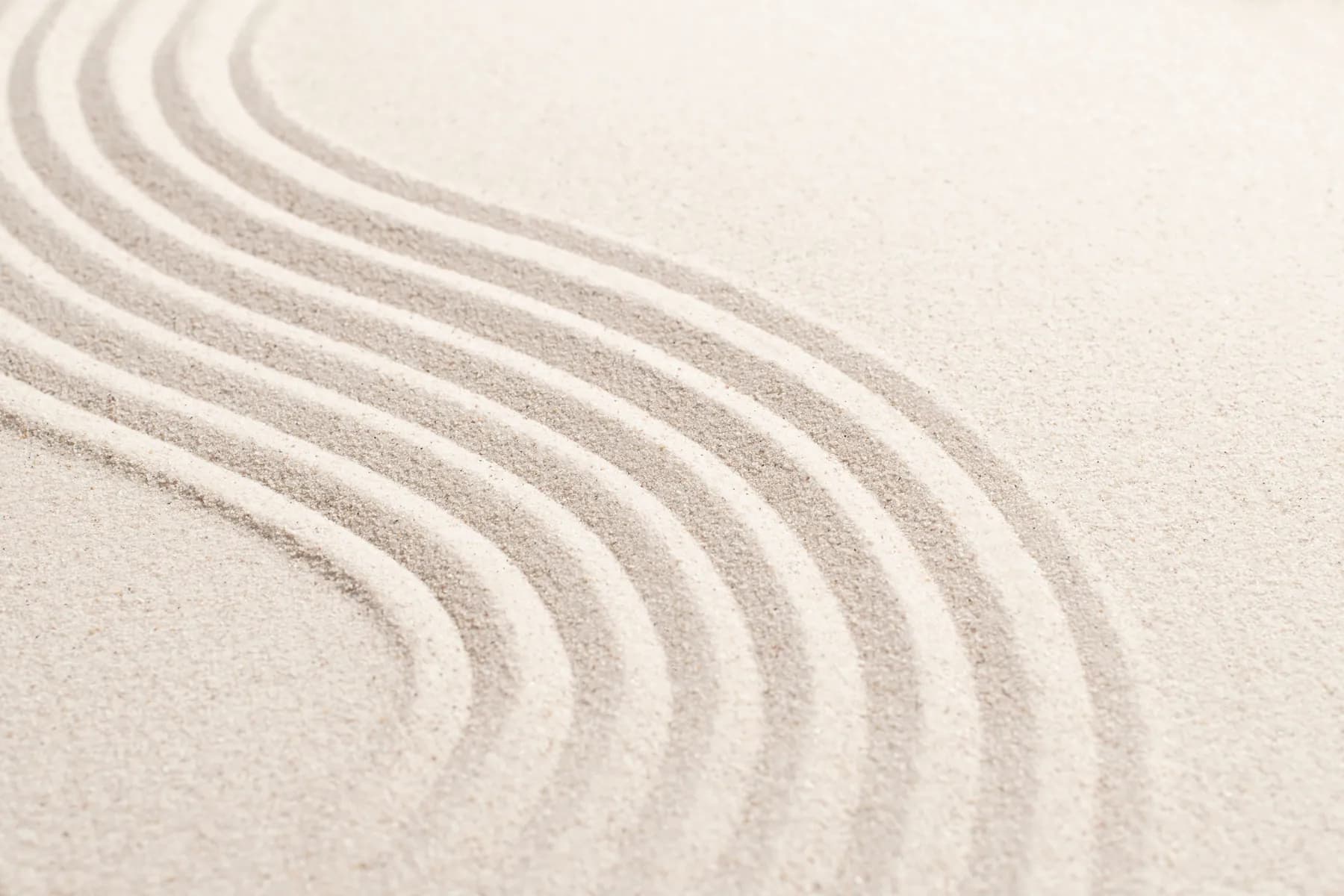 Parallel sweeping lines moving through pale sand